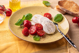 Veganer 'Mozzarella' mit Olivenöl, Tomaten und Basilikum