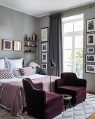 Pair of velvet armchairs at the foot of a bed