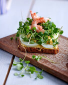 An open sandwich with boiled egg, prawns and cress