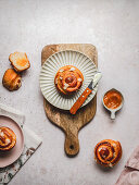 Cinnamon bun with almond flakes and knife with cream