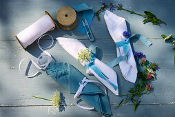 Decorated linen napkins with ribbons and wild flowers