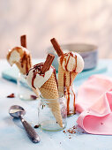 Vanilla ice cream with chocolate sauce and chocolate rolls in ice cream cones