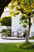 Seating and flower pots on wooden decking at foot of outside steps