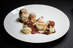 Profiteroles drizzled with chocolate sauce