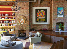 Seating area in front of fireplace in a spacious room with brick walls