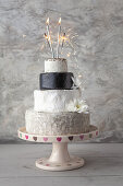 Cheese Wedding Cake - Käsesorten als mehrstöckige Hochzeitstorte arrangiert, mit Wunderkerzen und Blüten