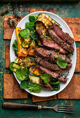 Roast beef steak with pepper and thyme on courgette salad