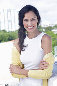 Dark-haired woman in white top and yellow cardigan