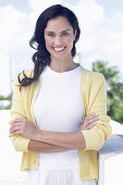 Dark-haired woman in white top and yellow cardigan