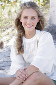 Young blonde woman in white blouse outdoors
