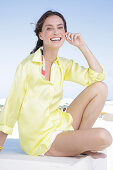 Brunette woman in yellow blouse and white shorts on the beach