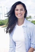 Dark-haired woman in white top and light blue shirt-blouse