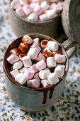 Close up of cup of hot spicy homemade chocolate winter drink with marshmallow and chocolate drips
