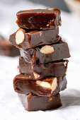 Stack of homemade toffee salted caramel chocolate almond nuts candy on crumpled paper