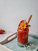 Strawberry smoothie with a yellow flower garnish