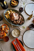 Table Setting with Roast Lamb and Potatoes with Red Wine, Butternut, Babaganoush