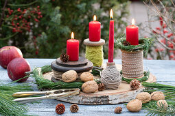 Ungewöhnlicher Adventskranz aus Garnrollen und roten Kerzen