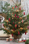 Nordmann fir tree decorated with yarn rolls and dried hydrangea blossoms