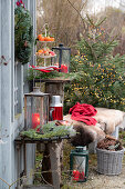 Christmas arrangement with lantern, tiered dessert tray, and bench with animal fur