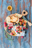 Brie with slices of toasted bread, figs, berries and honey