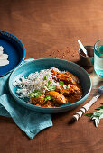Butter chicken curry (murgh makhani) with rice and coriander