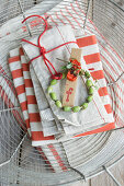 Napkin, name card, silver spoon and wreath of poppy pods