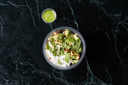 A healthy bowl with avocado, rocket and pine nuts to take away