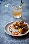 Spicy roasted cauliflower and potatoes with a cocktail