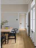 Light wood table and classic chairs in dining room with beige walls