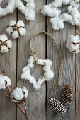 Garland with a cotton star and whitewashed pine cones on a wooden background