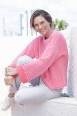 Woman in pink sweater and white pants