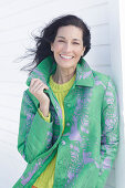 Mature, dark-haired woman in a green coat