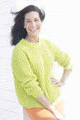 Mature, dark-haired woman in a green and yellow knit sweater