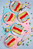 Rainbow sponge cake with chocolate colored dragees on plates