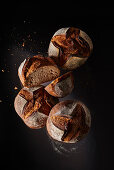 Rustic farmhouse bread against a black background