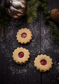 Spitzbuben with strawberry jam on a dark wooden base