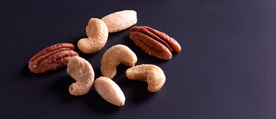 Cashews, almonds and pecans on a dark background