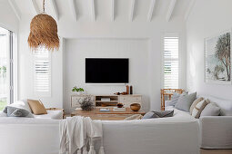 Seating area with upholstered sofa and tv in living room interior with white walls