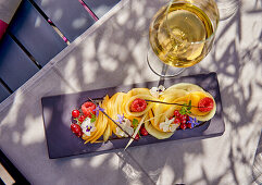 Honigmelone mit roten Beeren, Blüten und Vanilleschoten