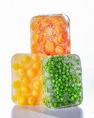 Peas, apricots, and carrots in ice blocks