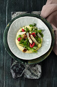 Asparagus zabaglione with wild herb and nut salad, avocado pearls and raspberries