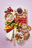 Picknickplatte mit Käse, Schinken, Gemüsesticks und Pickles