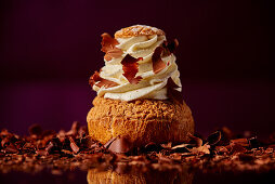 Chocolate cream puff with cream and chocolate shavings