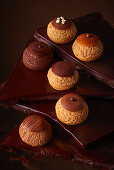 Assorted mini cream puffs with chocolate, coffee, and caramel flavors