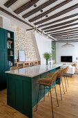 Kitchen island with petrol-colored fronts as worktop and dining table