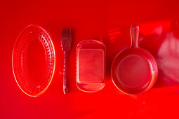 Küchenutensilien auf rotem Untergrund