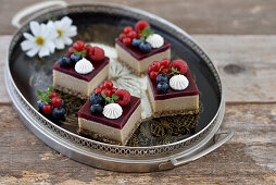Raw vegan cashew date cubes with wild berry fruit glaze and berries