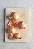 Onion and onion skins on a wooden cutting board