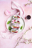 Regenbogen-Onigirazu-Sandwiches mit Spinat, Rübe, Avocado und Räucherlachs dazu rosa Joghurtsauce