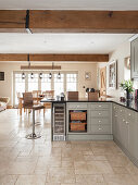 Light country-style fitted kitchen in the corner, dining area in the background